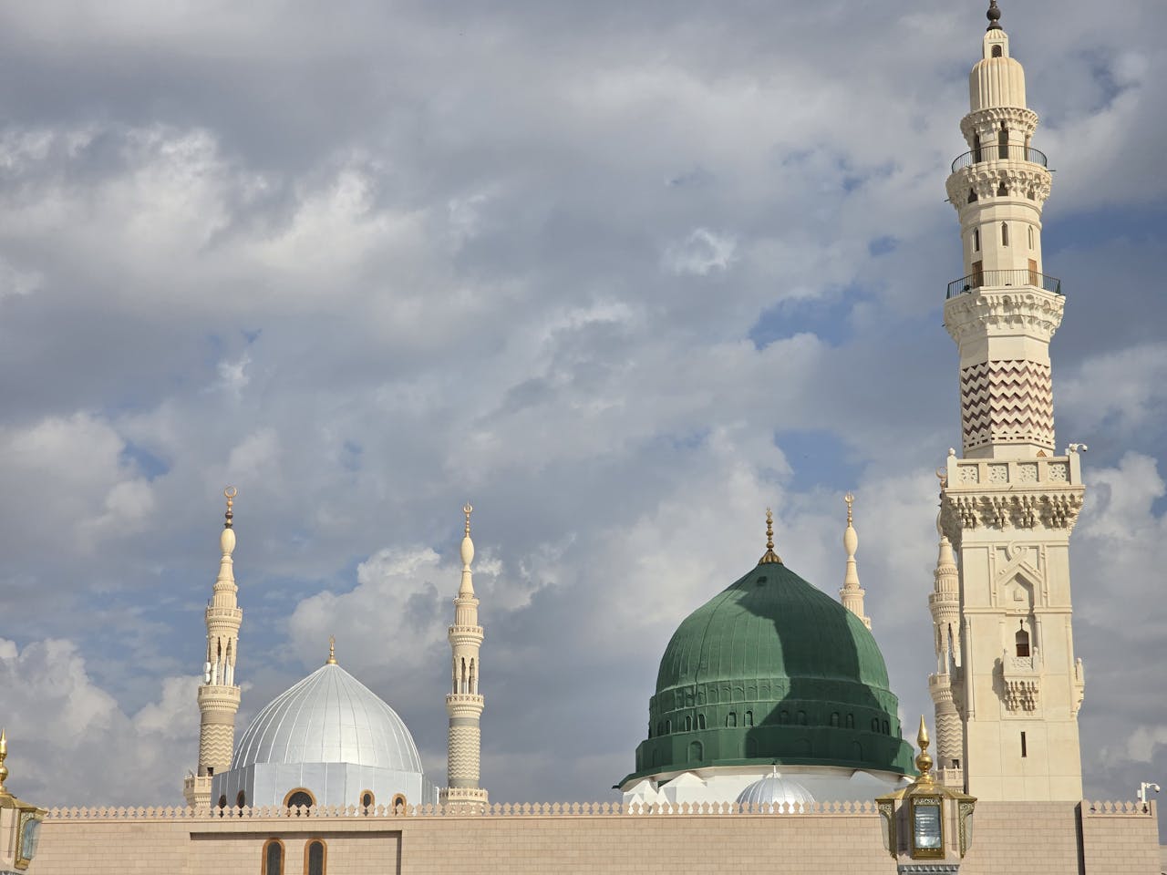 Stunning view of Prophet's Mosque showcasing the iconic Green Dome against cloudy skies.